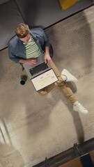 Aufkleber - Vertical Screen Top View Apartment: Man Uses Laptop Sitting on a carpet in Living Room. Creative Freelancer Working Remotely From Home. Stylish Entrepreneur doing E-business Project, Online Shopping
