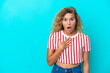Girl with curly hair isolated on blue background surprised and shocked while looking right