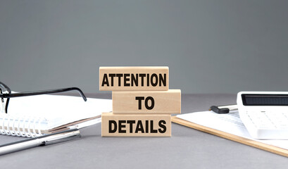 Poster - ATTENTION TO DETAILS text on wooden block with notebook,chart and calculator, grey background