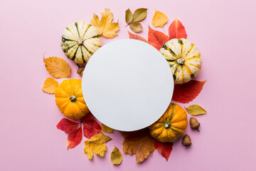 Wall Mural - Autumn composition with round paper blank and dried leaves with pumpkin on table. Flat lay, top view, copy space