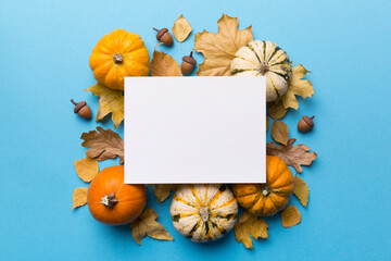 Wall Mural - autumn composition with paper blank and dried leaves with pumpkin on table. flat lay, top view, copy