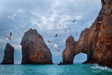 Wall Mural - Rocky formations at stormy clouds. Famous arches of Los Cabos. Mexico. Baja California Sur.