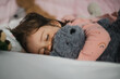 Kleines Mädchen schläft mit ihrem Kuscheltier