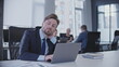 © Synthex - Sleepy male manager sitting at workplace in business office, tired of overworking