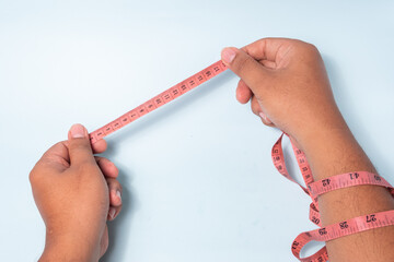 an asian man's hand is measuring using a tape measure, which tailors usually use, isolated on a white background