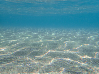 Tropical blue ocean with white sand underwater in Mediterranean Sea. Ocean background, underwater blue ocean background with sandy sea bottom, Blue deep water abstract natural background.