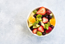 Healthy Fresh Fruit Salad In Bowl On Gray Concrete Background. Top View. Copy Space.