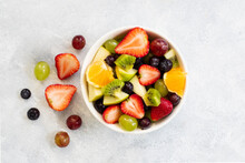 Healthy Fresh Fruit Salad In Bowl On Gray Concrete Background. Top View. 