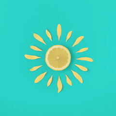 Wall Mural - Sun made of lemon and yellow flower petals on bright blue background. Fruit summer minimal concept.Summer creative art. Minimal citrus fruits aesthetic.