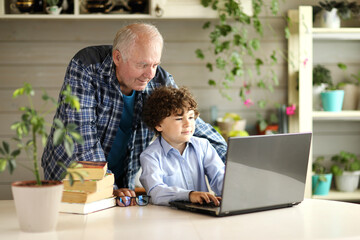 Grandfather and grandson study on the computer at home ,back to school