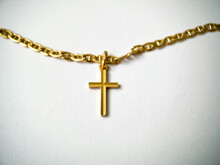 Gold Cross On A Gold Chain Close-up On A White Isolated Background