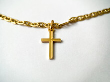 Gold Cross On A Gold Chain Close-up On A White Isolated Background