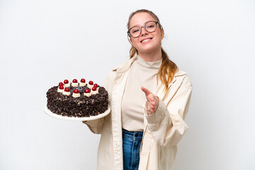 Poster - Young caucasian woman holding a Birthday cake isolated on white background shaking hands for closing a good deal