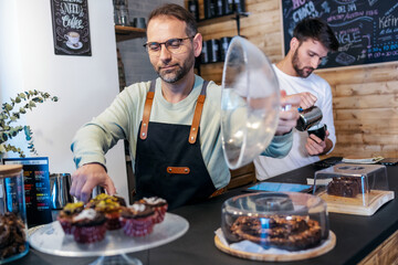 Shot of two handsome waiters preparing the order to serve to customers in a healthy coffee shop.