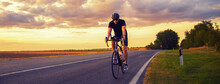 Young Sports Man Biker Cycling With Bicycle On The Road In Summer