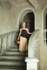 Wall Mural - Young blonde woman wearing retro dress going down vintage stairs