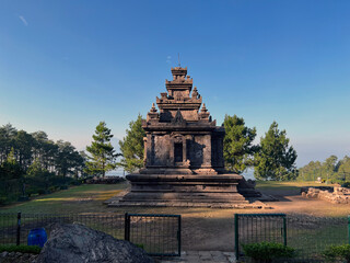 Gedongsongo Hindu Temple with bright clear blue sky and forest mountains in background as a popular tourist attraction  in Indonesia South East Asia