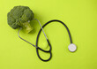 © splitov27 - Healthy food concept. Broccoli with stethoscope on green background. Top view
