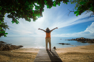 happy woman stand on wood bridge with view of the sea, soft focus with noise