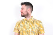 © Jihan - Side view of young happy smiling Young caucasian man wearing Hawaiian t-shirt over white background