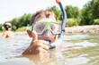 a guy in a diving mask with a snorkel swims in the water