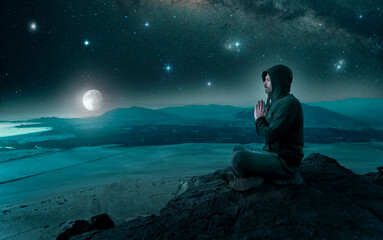 Wall Mural - person sitting on the top of the mountain meditating or contemplating the starry night with full moo