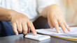 © chinnarach - close up senior woman hand use calculator for counting about expenses monthly or spending money in living room for financial and economy lifestyle concept