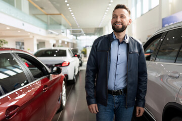 Wall Mural - a man in a car dealership chooses a new car considering options