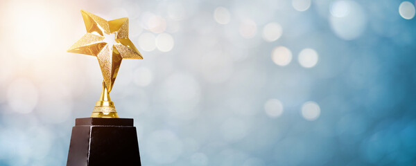 golden trophy award bokeh soft blue background. copy space for text. winner or 1st place gold trophy