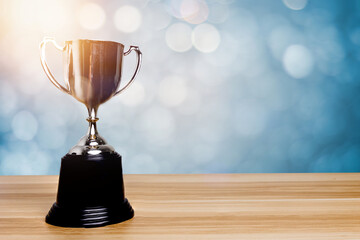 Wall Mural - golden trophy award bokeh soft blue background. copy space for text. winner or 1st place gold trophy