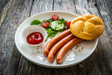 Breakfast - Boiled Sausages, Bread And Fresh Vegetables Served On Wooden Table
