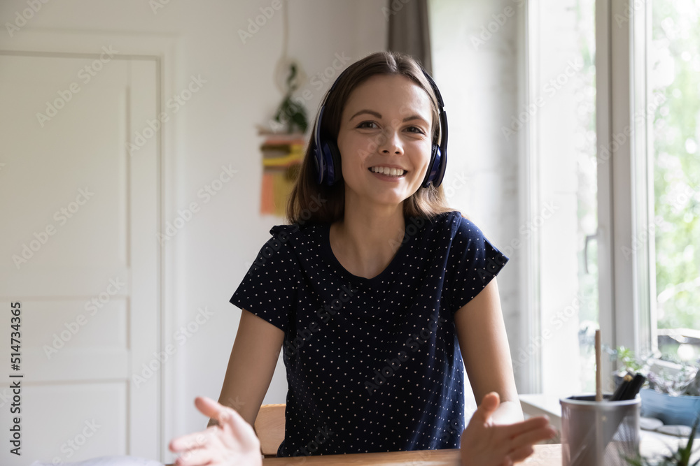 Happy young teacher woman in wireless headphones giving online lesson ...