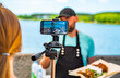 man chef gives an interview for a video blogger. videographer is filming the cook's story about cooking. outdoor