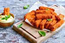 Close Up Of   Crispy Breaded  Deep Fried Fish Fingers With Breadcrumbs Served  With Remoulade Sauce And  Lemon Cod Fish Nuggets On Rustic Wood Table Background