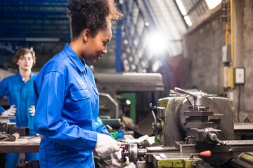 Wall Mural - African American Young woman worker  in protective uniform operating machine at factory Industrial.People working in industry.Portrait of Female  Engineer at work place.