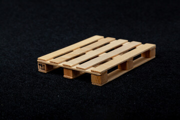 Reduced model wooden euro pallet on black felt background....