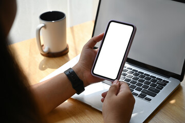 Poster - Over shoulder and Close up with Asian female using smartphone and laptop, blank screen of devices, Domestic life concept.