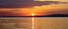 Sunset Over Aegean Sea. Greece. Golden Reflection On Rippled Ocean Water. Dark Land And Colorful Sky
