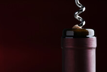 Opening Bottle Of Wine With Corkscrew On Dark Background, Closeup. Space For Text