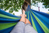 Fototapeta Lawenda - Wypoczynek na hamaku pod drzewem jest dobrym sposobem na relaks w ciepłe dni.