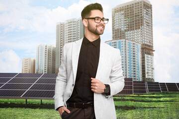 Wall Mural - Young businessman near solar panels and beautiful view of cityscape. Alternative energy source