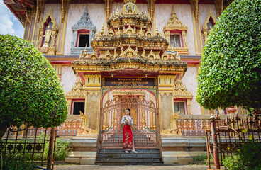 Beautiful Asian girl at big Buddhist temple dressed in traditional costume