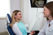 © Tania - She is sitting in the dentist's chair. The dentist explains and advises the patient.