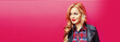 © rohappy - Portrait of beautiful blonde young woman with red lipstick wearing black rock jacket on pink background