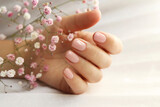 Light pink manicure on short nails with Gypsophila.