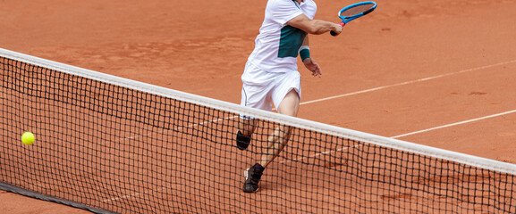 Wall Mural - Male tennis player in action on the court on a sunny day. Professional sport concept. Horizontal sport poster, greeting cards, headers, website