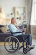 © Mediaphotos - Serious senior man with gray hair sitting in wheelchair and surfing net on tablet while spending time at home