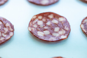 Wall Mural - Top and side views of smoked salami sausage slices isolated on blue background