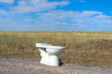 the toilet is in an open field. mobile toilet