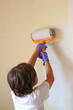© TopMicrobialStock - Child painting with a roller at home